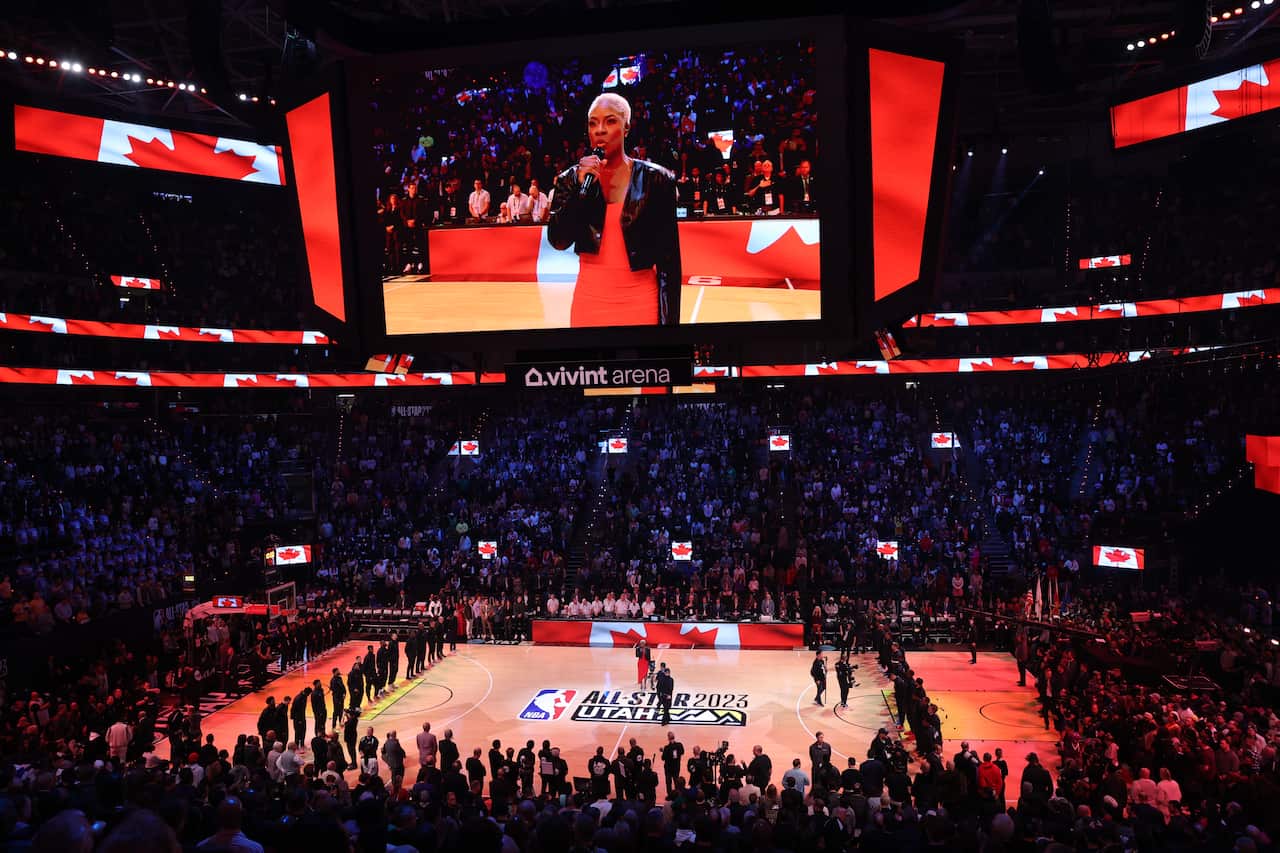 Crowd at a basketball game stands up. 