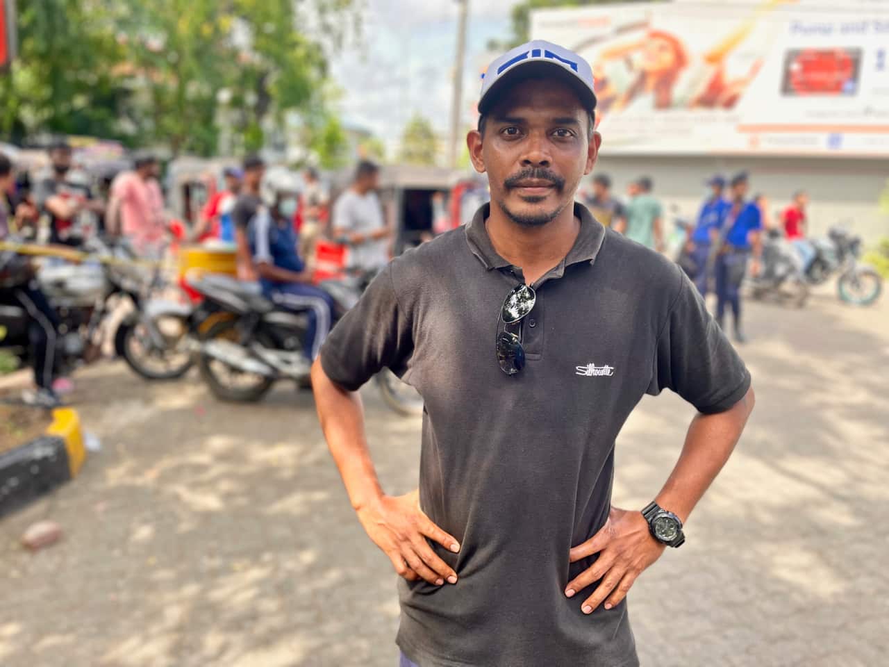Brian Jason stands in front of a queue in Colombo. He spent six days away from his wife and child waiting for fuel