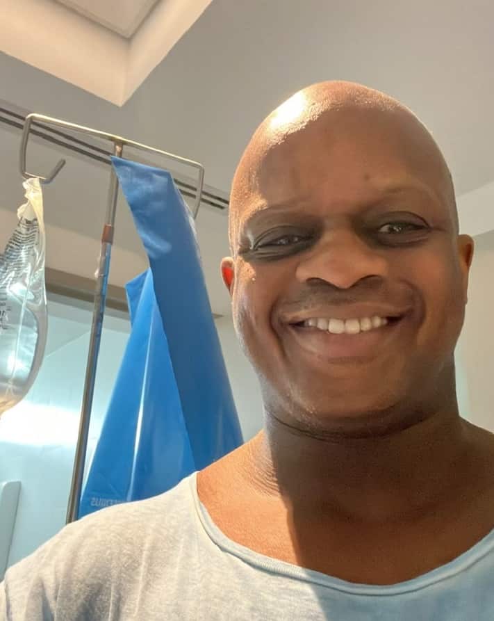 DJ in hospital with hospital equipment behind him.