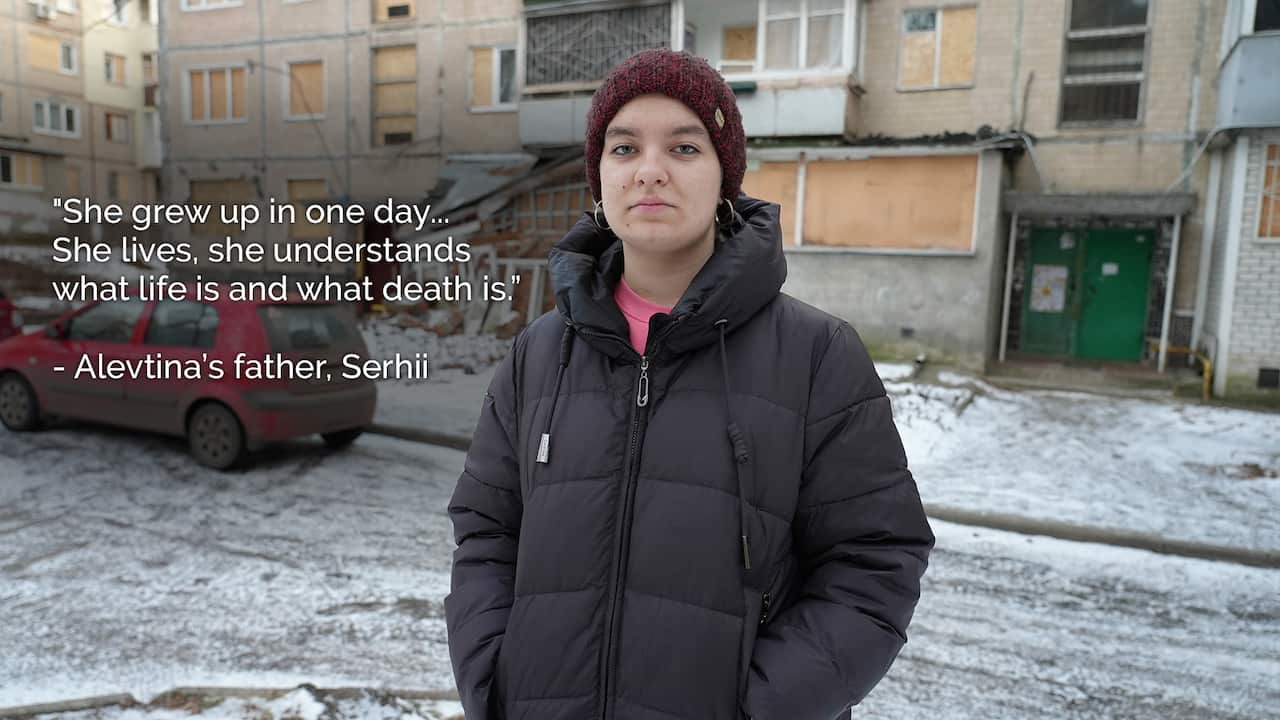 A teenager stands outside a damaged unit block.