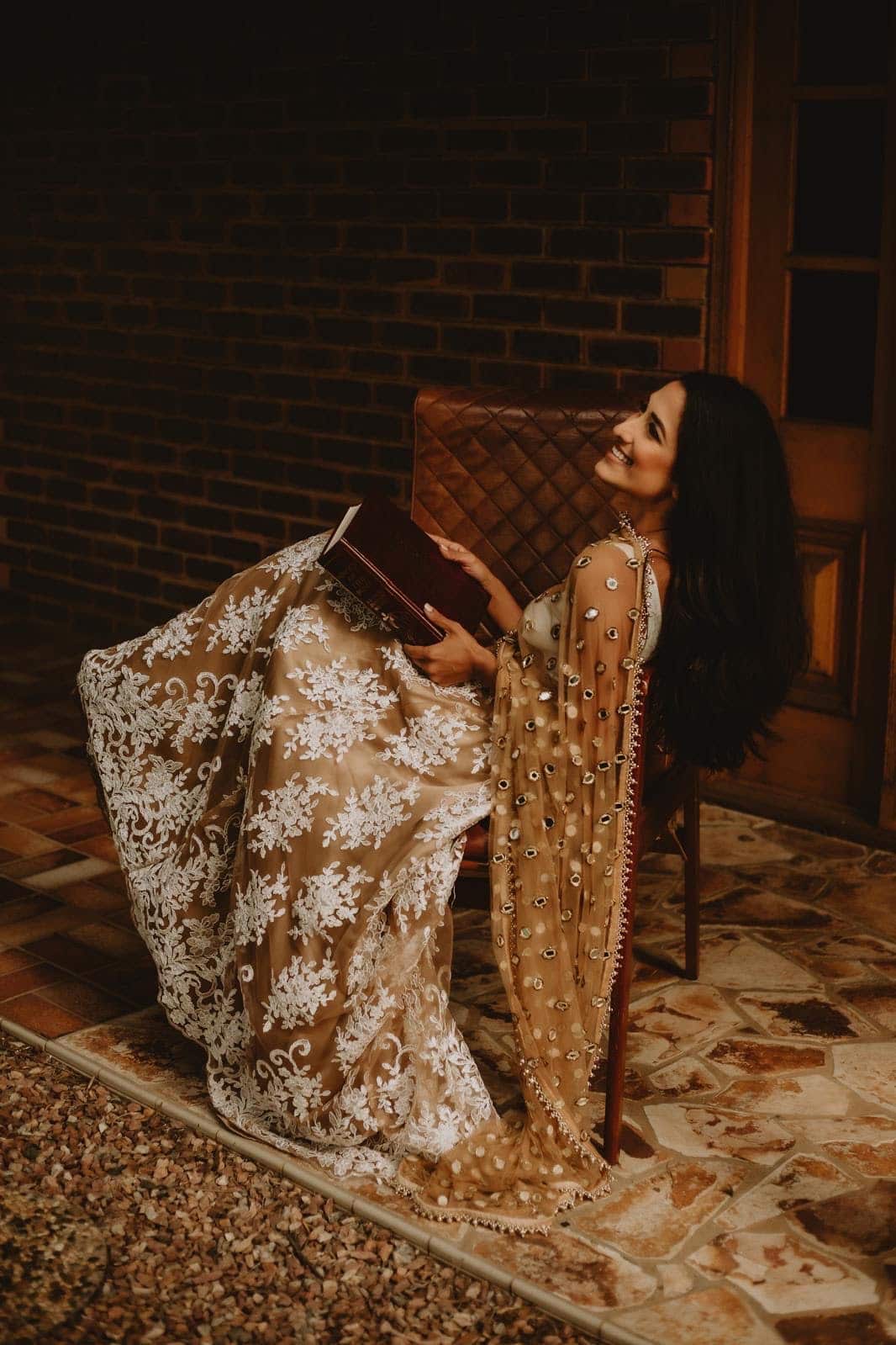 a woman wearing a sari holding a book