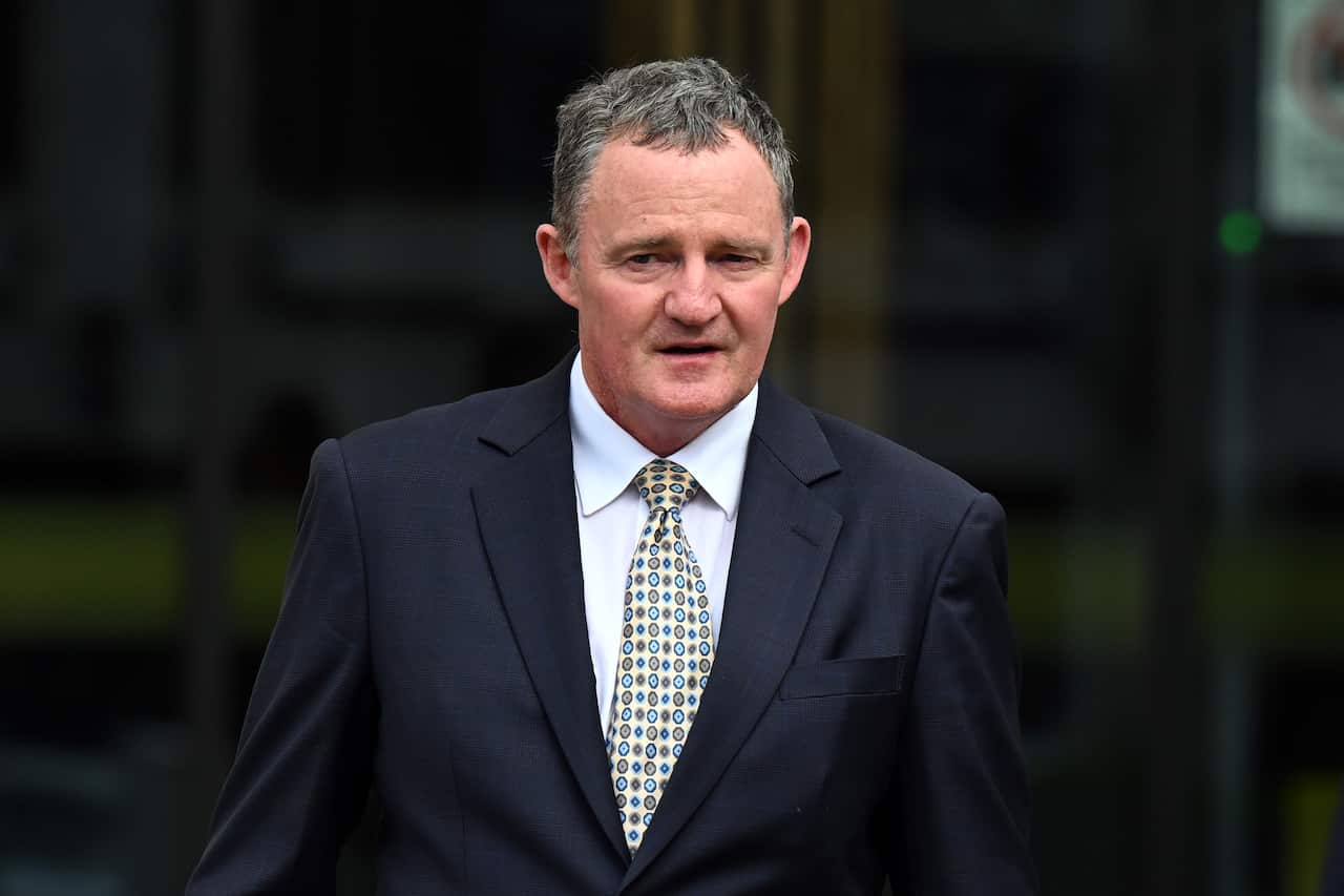 A man wearing a suit and tie arriving at the ACT Supreme Court.