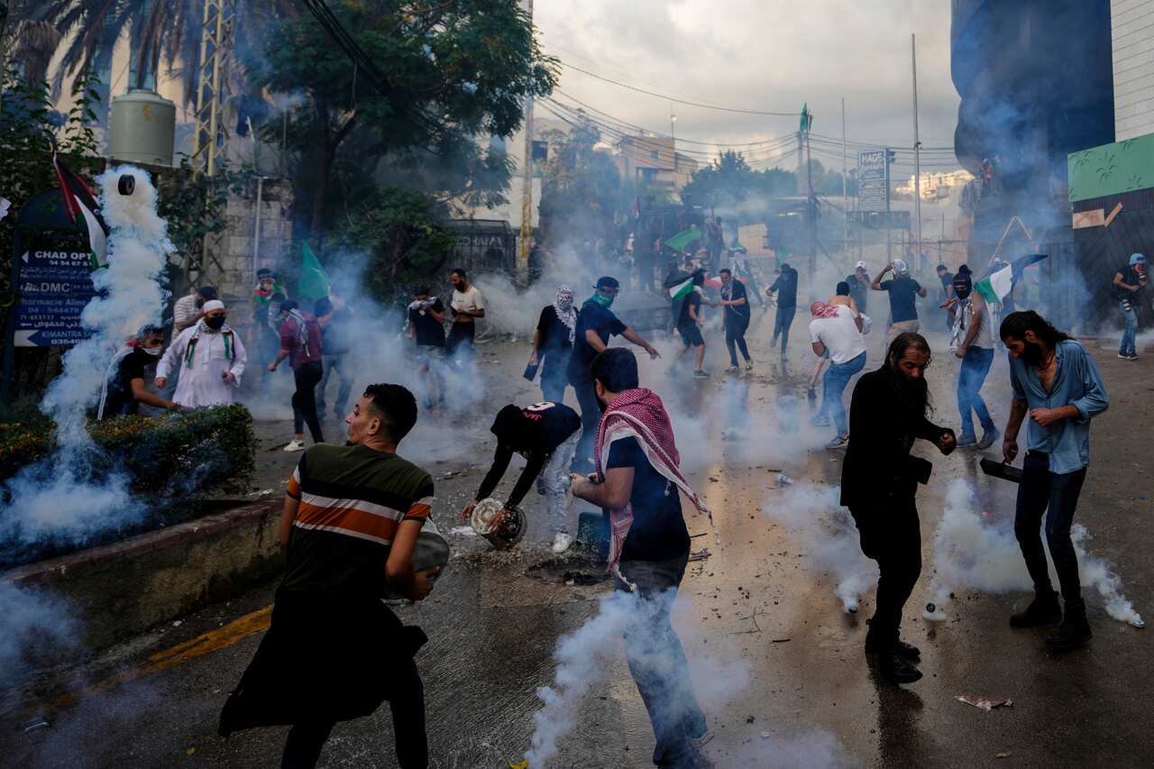 Tear gas is fired at protesters on the street.