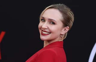 A blonde woman with red lipstick smiles at the camera
