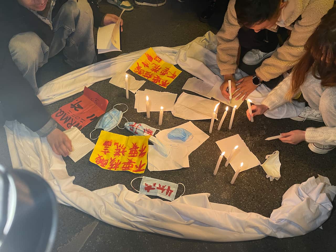 People in Chendgu hold vigil for Urumqi fire victims on Sunday evening. 