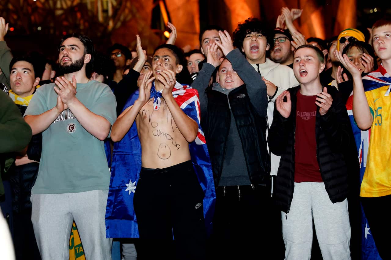 People standing outside clapping and cheering.