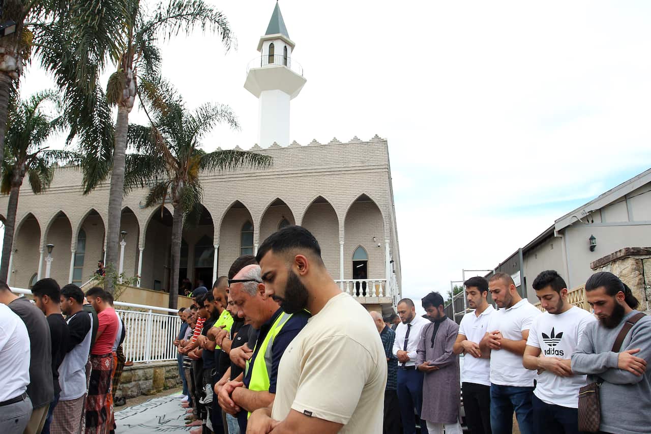 Men praying on a street outside a mosque in Sydney