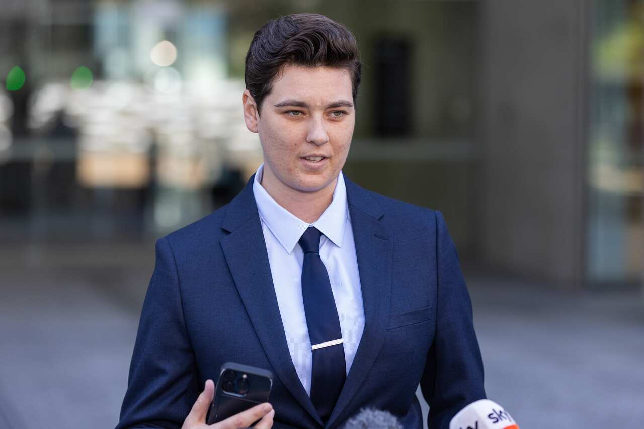 A woman in a dark suit and tie 