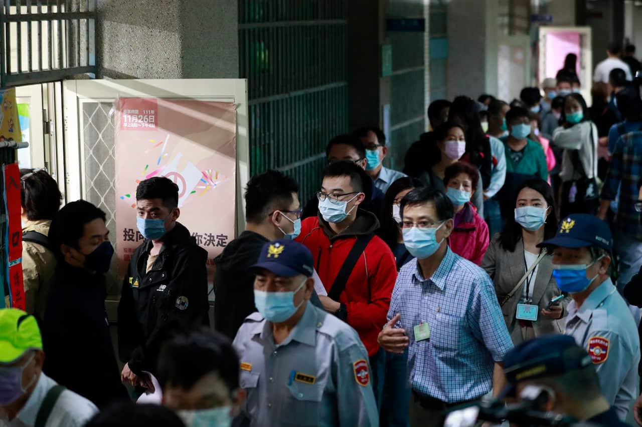 People line up to cast votes in local elections at a polling station in Taipei, Taiwan.