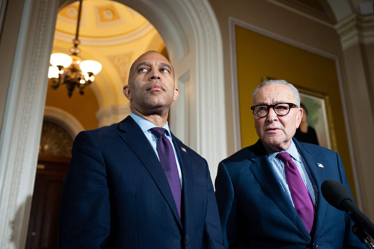 Two men in suits standing next to each other inside