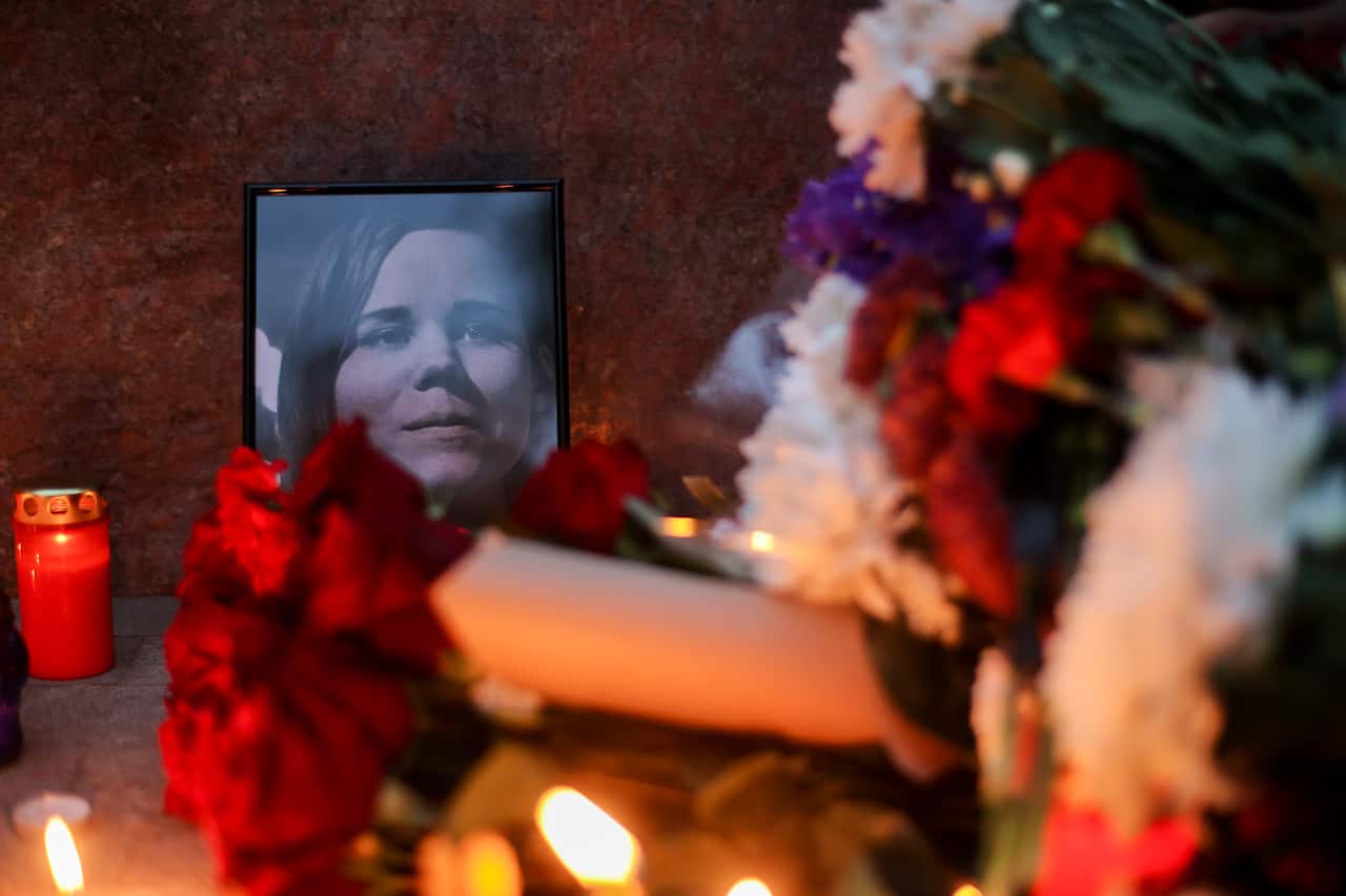 A memorial with flowers and a photo of Daria Dugina.