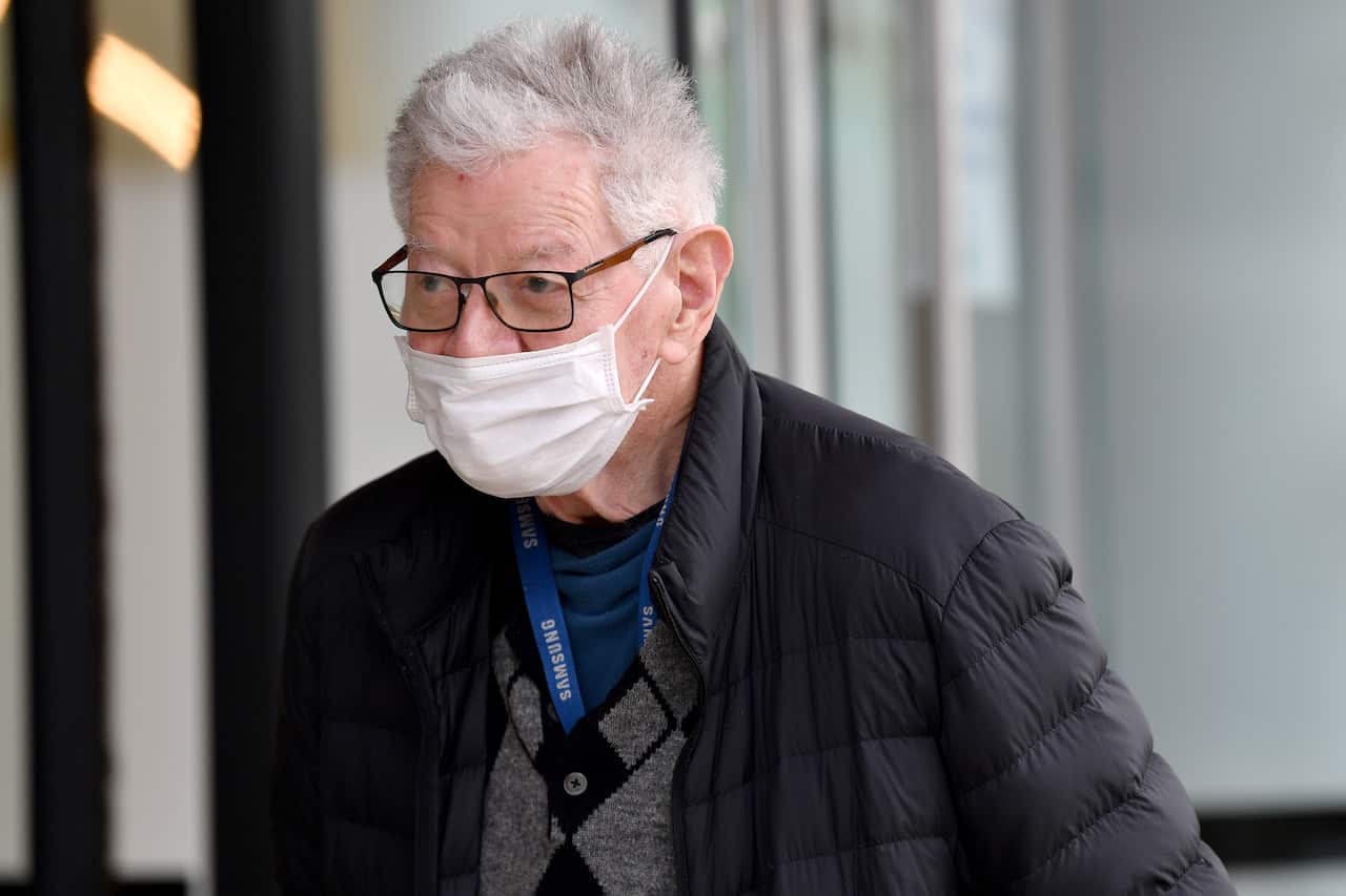An elderly man with a face mask and glasses on