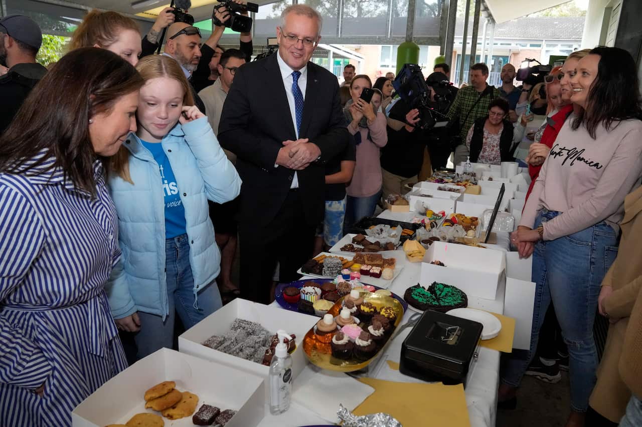 A man, his wife, and their daughter looking at baked goods at a stall.