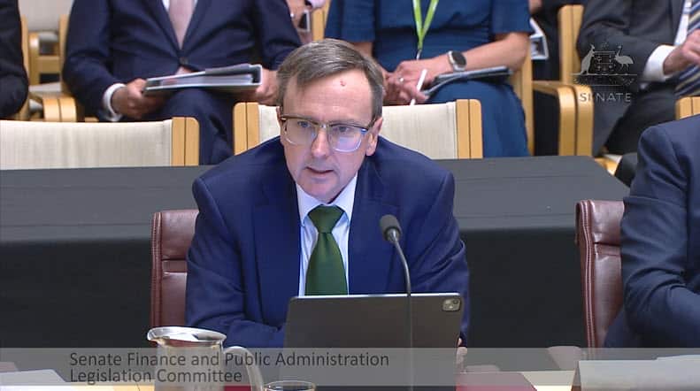 A man at a desk in a blue suit