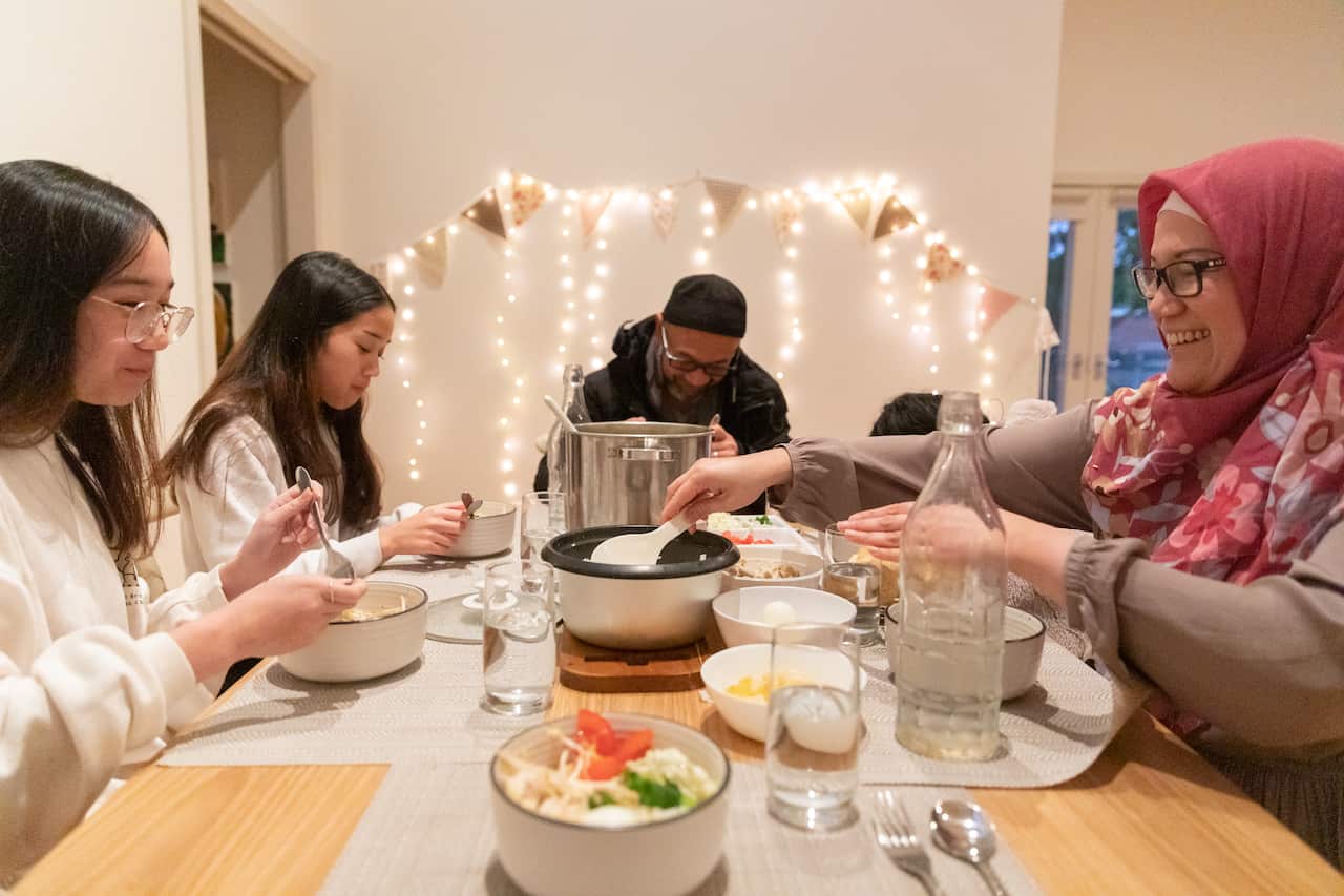 People eat together at a dinner table. 