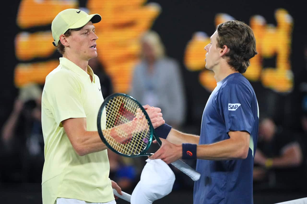 Two tennis players congratulate each other at the net.