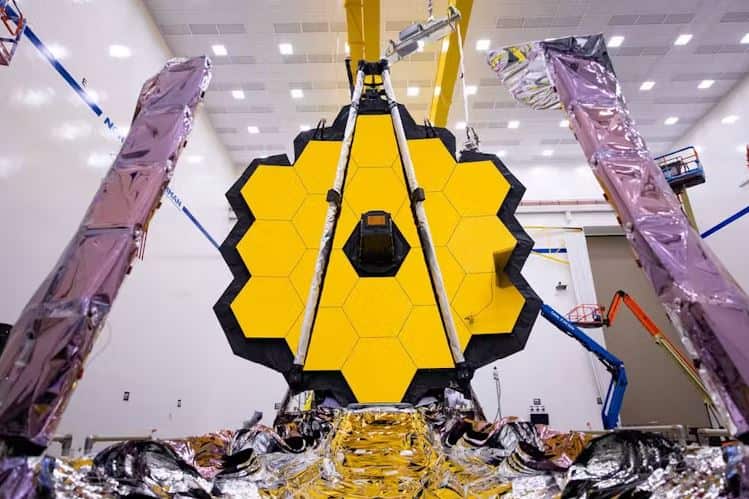A yellow honeycombed mirror sits in a white warehouse.