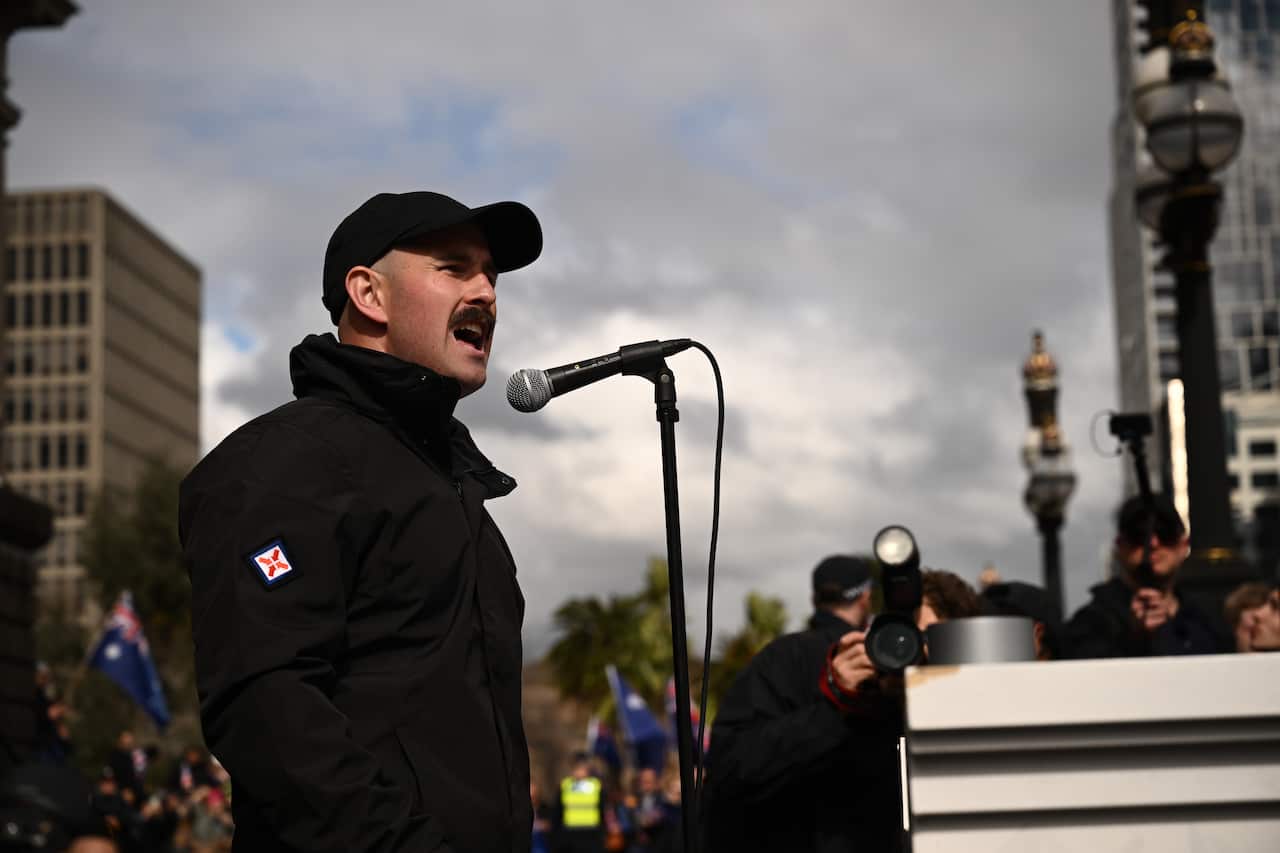 Thomas Sewell speaking into a microphone.