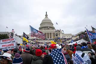 A group of Trump supporters gather outside the US Capitol waving flags and signs