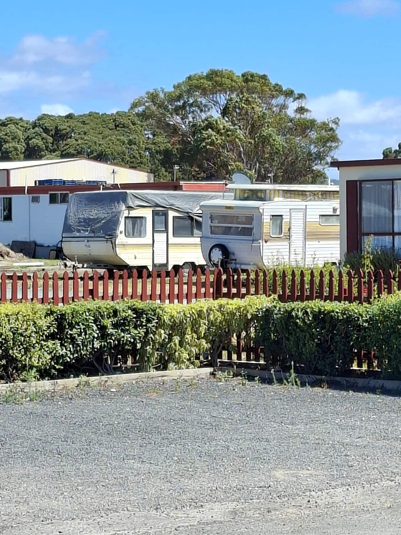 A photo of two old caravans in the midday sun.
