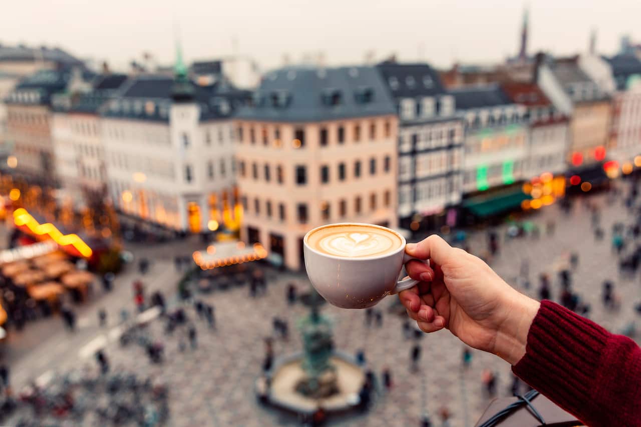 Man drinking coffee with a view of Copenhagen skyline, Denmark