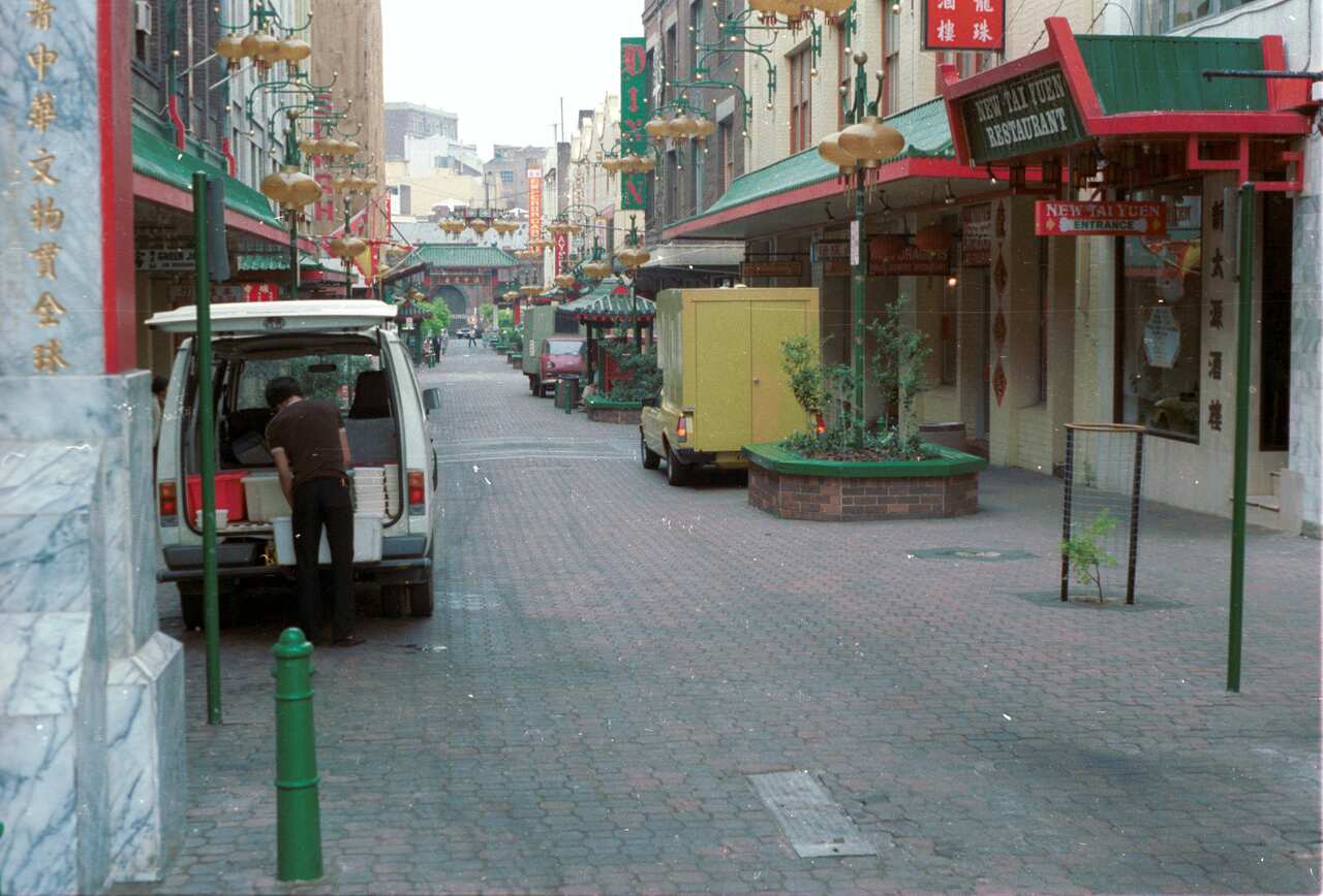 Looking south along Dixon Street pedestrian mall from the commemorative gates near Factory Street towards the commemorative gateway at Hay Street where a man is unloading a van on the left and the New Tai Yuen Restaura