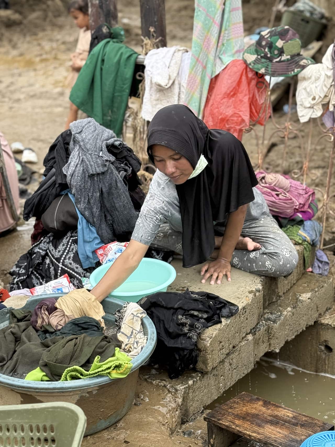 A woman sorts through wet baskets of clothes
