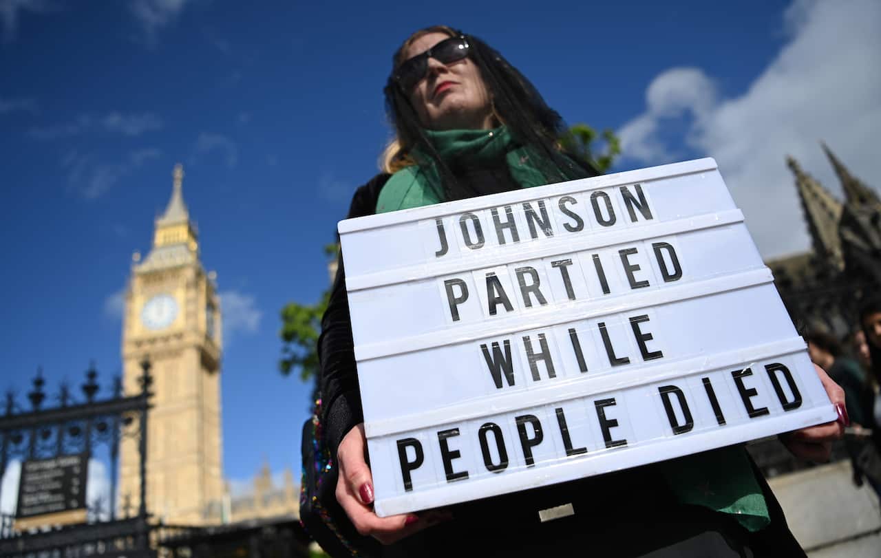 A protester demonstrates against the Downing Street parties, outside UK parliament in London