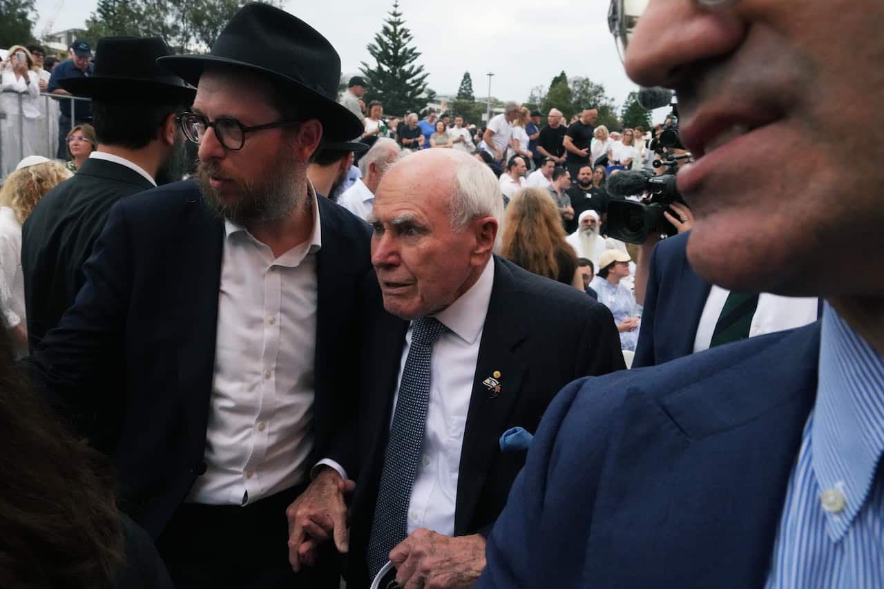 Australia's former Prime Minister John Howard, center, arrives at Bondi Beach before a ceremony to mark the National Day of Reflection 