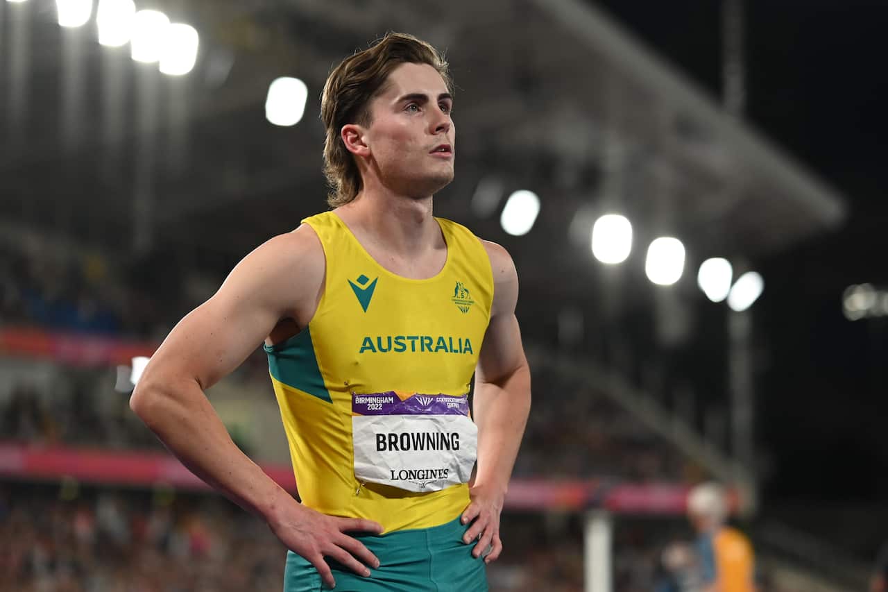 Rohan Browning stands in a yellow singlet with a mullet. 