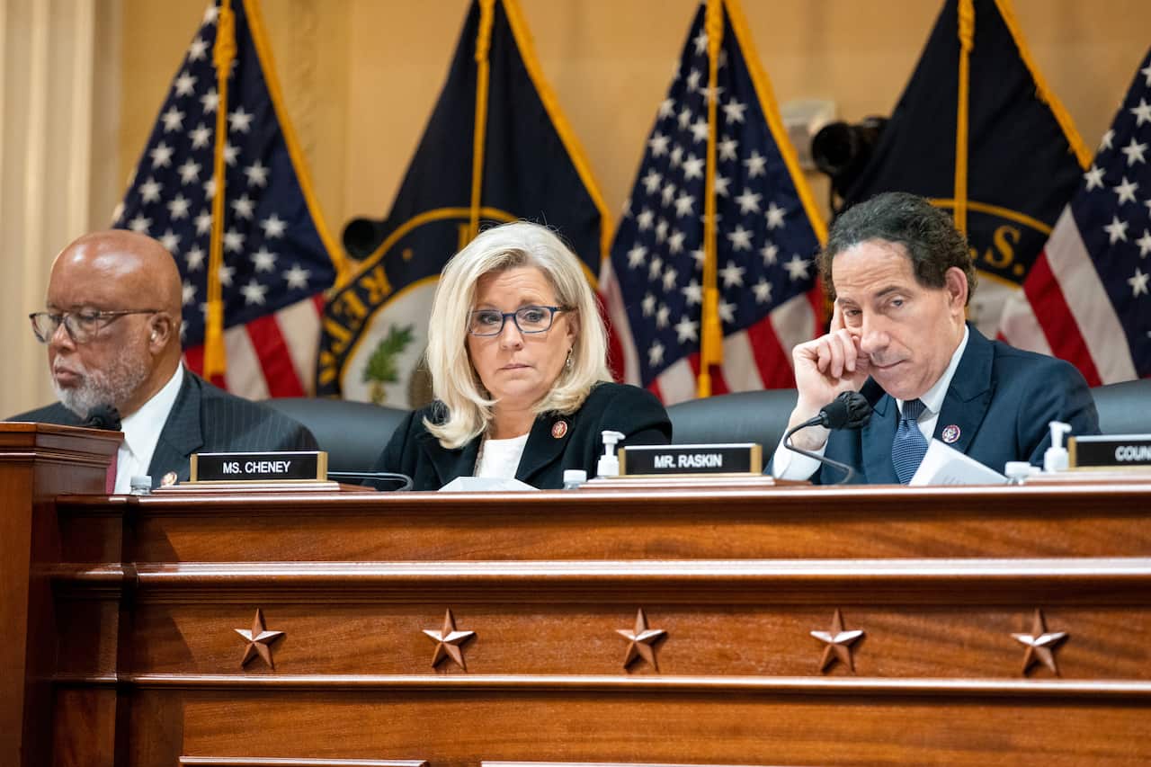 An African American man, a white woman, and a white man sit on a panel.