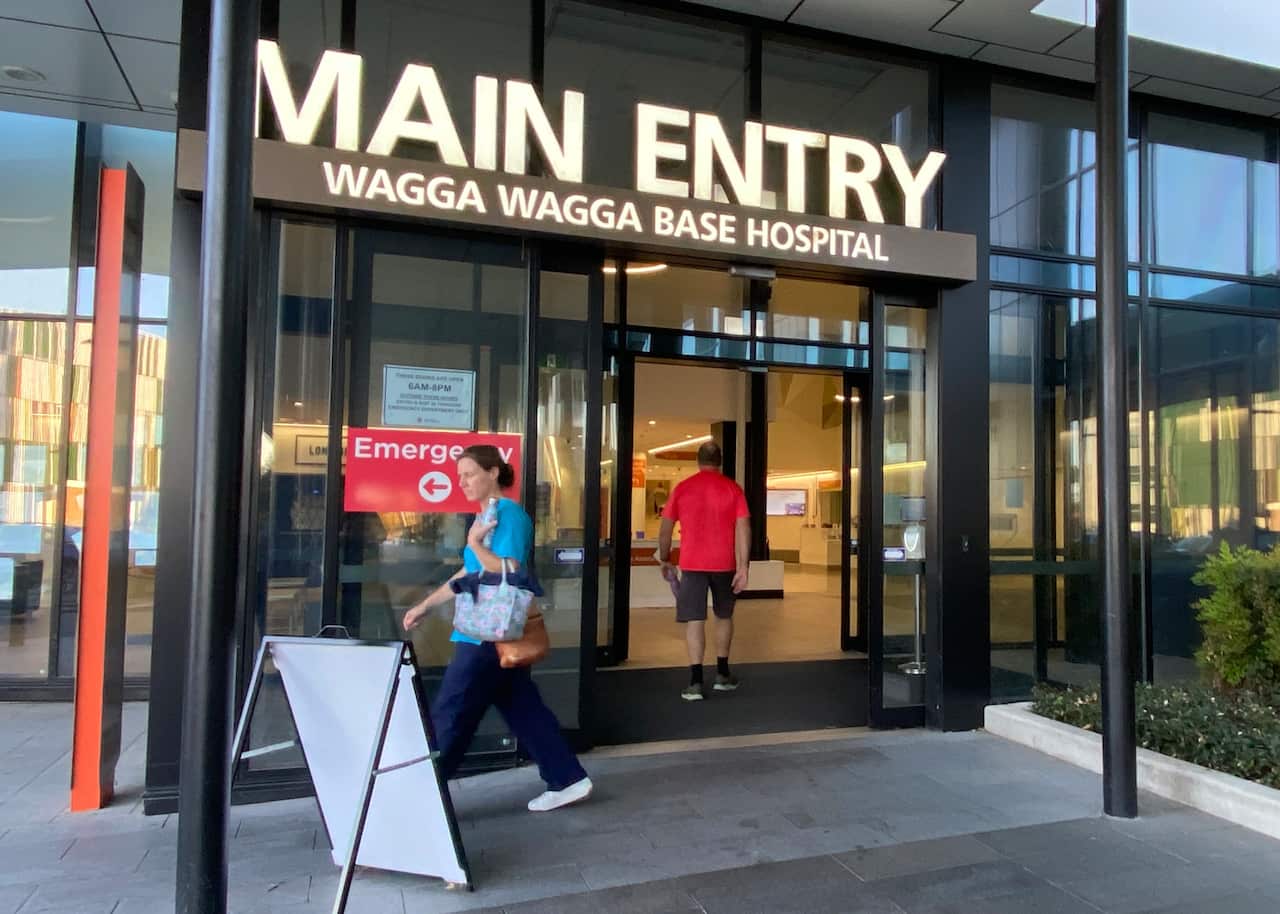 The entry of a building. A large sign above the doors reads Main Entry. A smaller sign below it reads Wagga Wagga Base Hospital