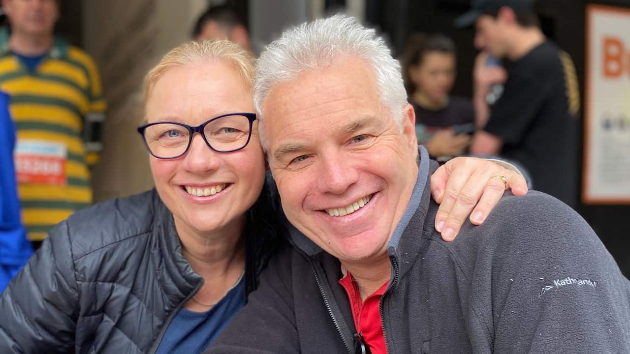 A woman with glasses and a man with short grey hair smiling together