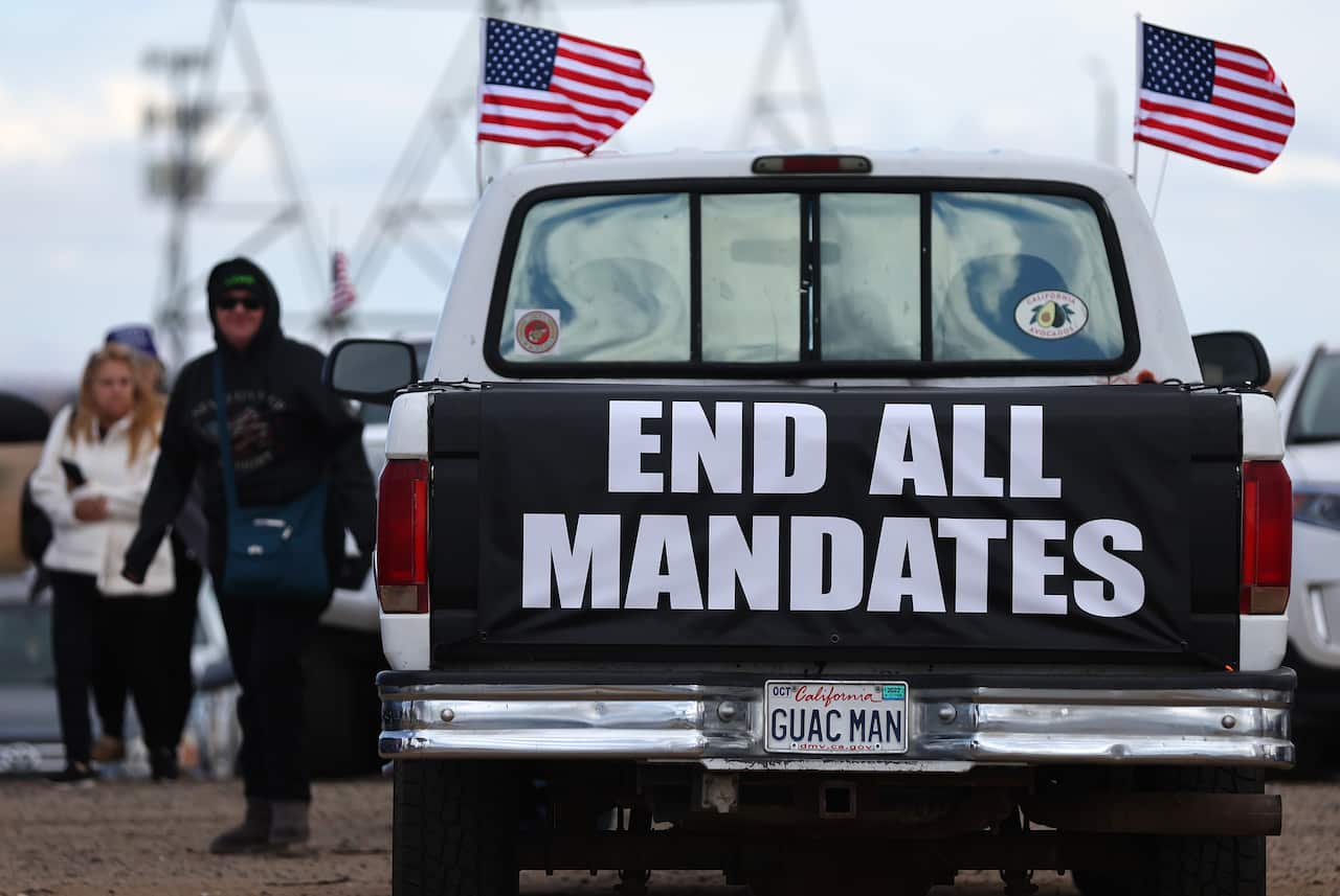 A ute is seen with an "end all mandates" sign at its rear.