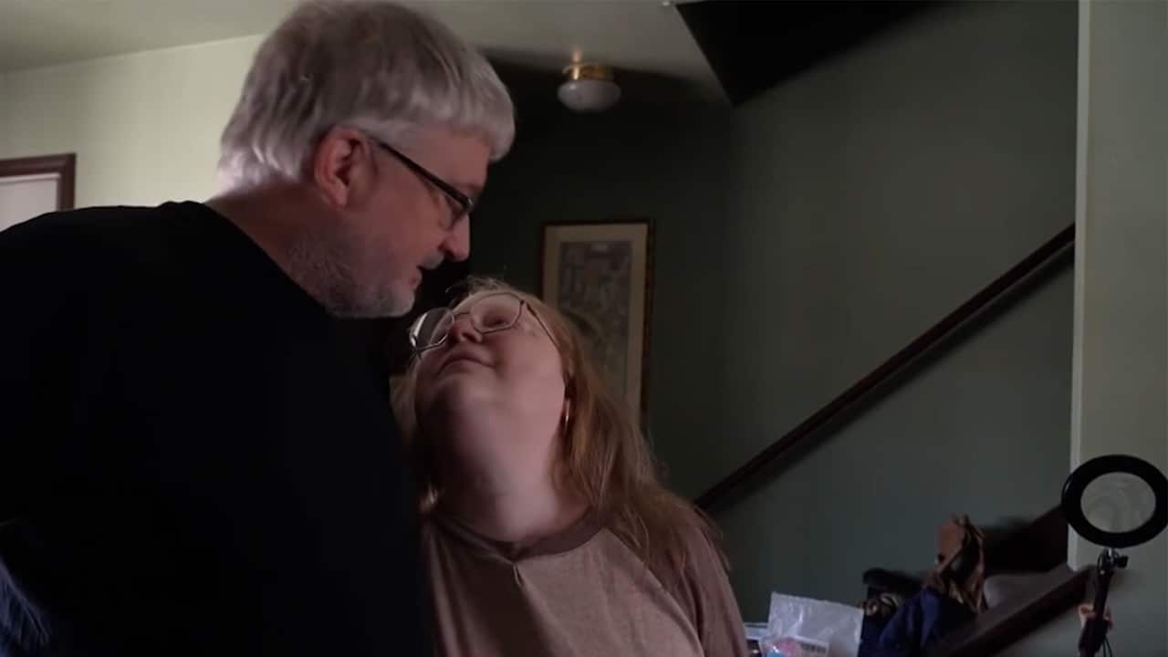 Jerry has his arm around his wife, Sarah who is battling cancer treatment. Sarah looks up at Jerry lovingly.