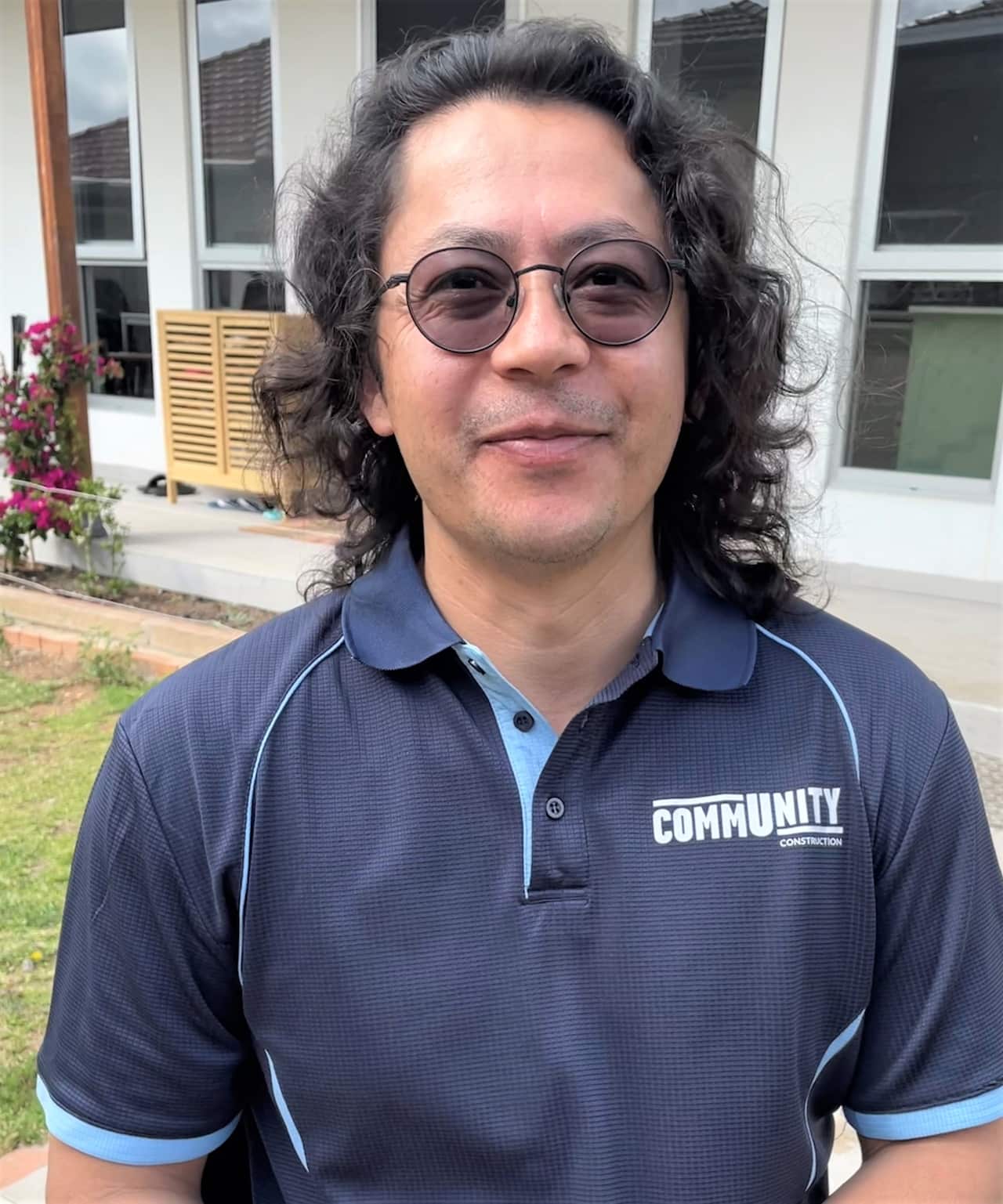 Hedayat Oysan sitting in a blue t-shirt at his home in Sydney.