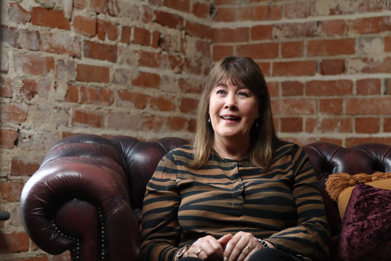 A woman sitting in a chair and talking. 