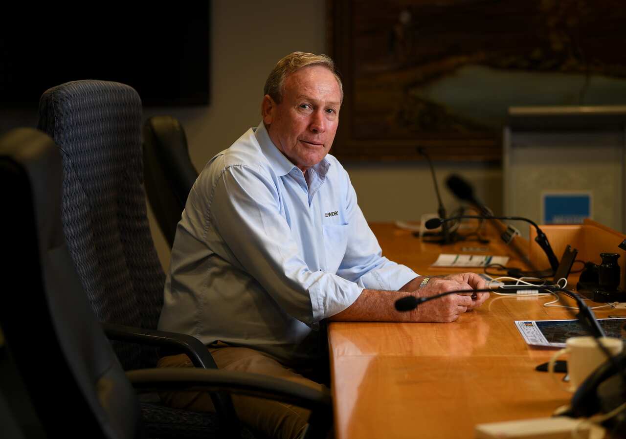 Western Downs Regional Council Mayor Paul McVeigh is seen sitting at a desk.