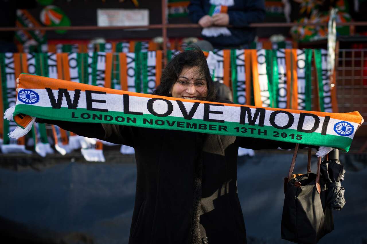 Woman holds scarf saying 'we love Modi'.