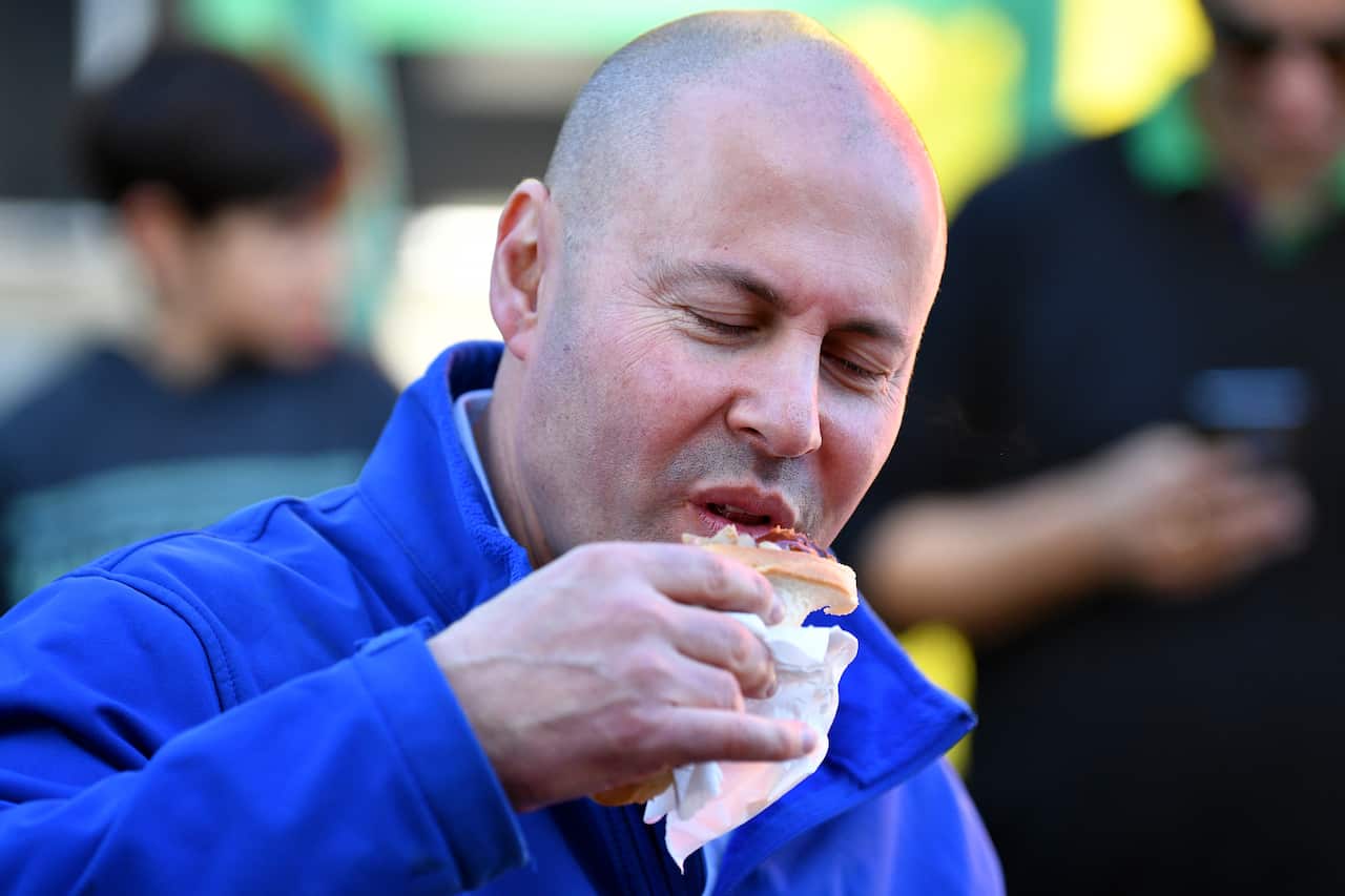 A man eating a sausage in bread.