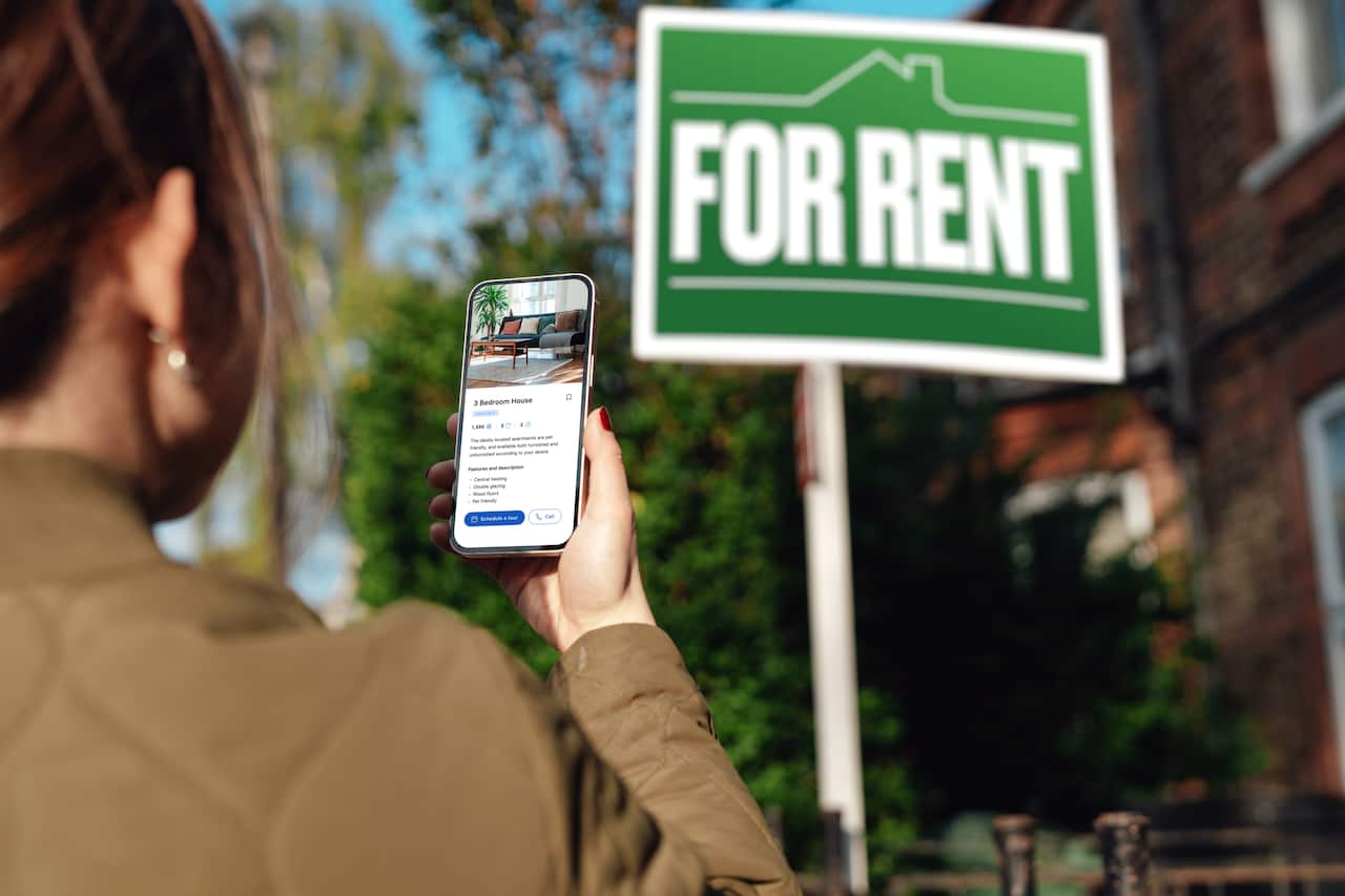 Woman looking for property to rent via real estate online platform on smartphone