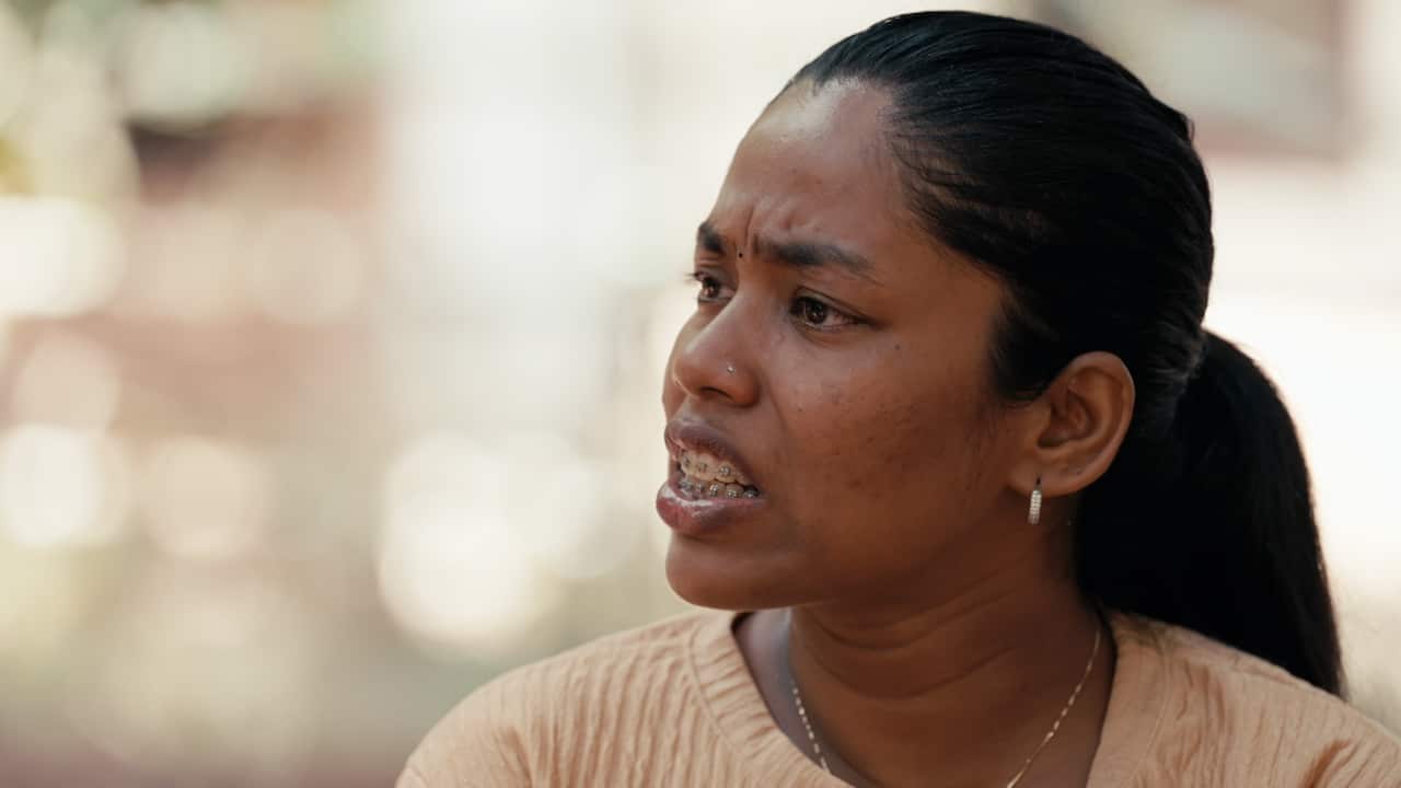 A woman looking to the side with a serious expression on her face.