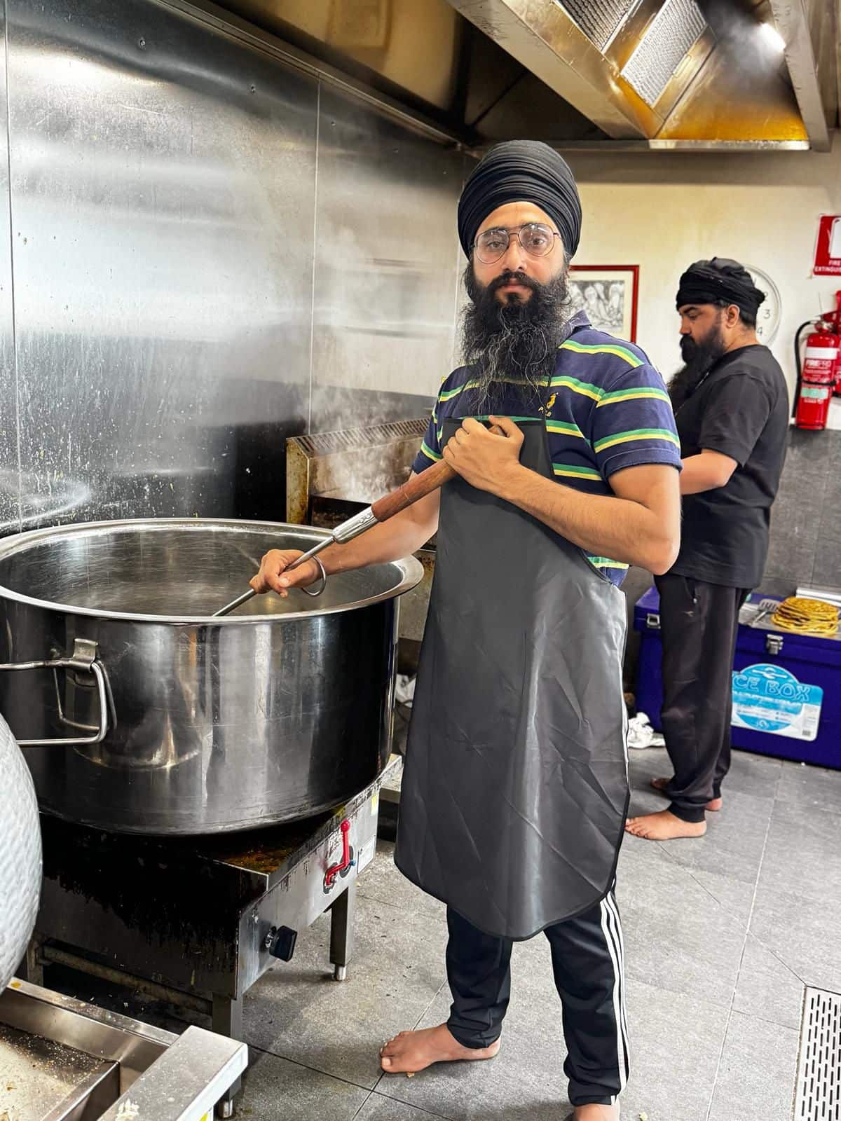 Image of volunteer cooking, credit to Gurdwara Siri Guru Nanak Darbar.jpg