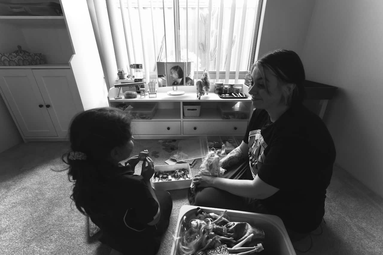 Black and white photo of a mother and child playing, inside a rental property.
