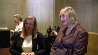 Two women in blazers with blonde hair are listening intently.