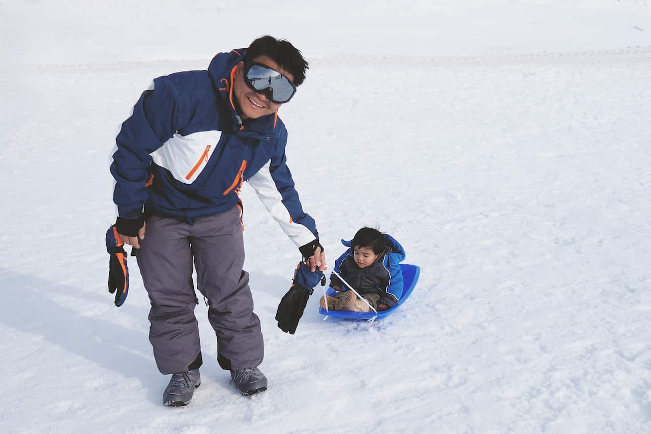Education - Dad and baby son is playing in the snow