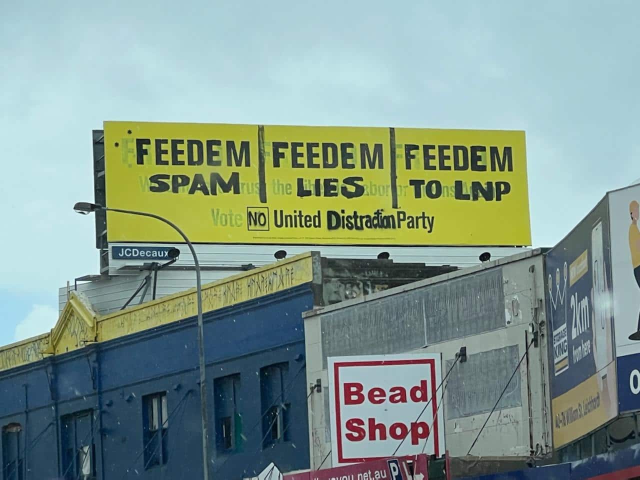 A vandalised United Australia Party billboard advertisement above a building on Sydney's Parramatta Road.