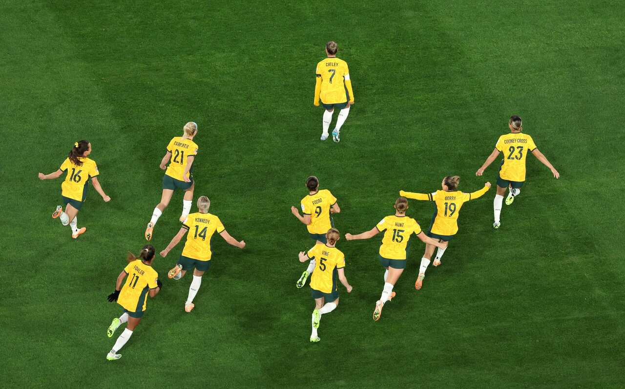 A group of women in yellow jerseys take to the field. 