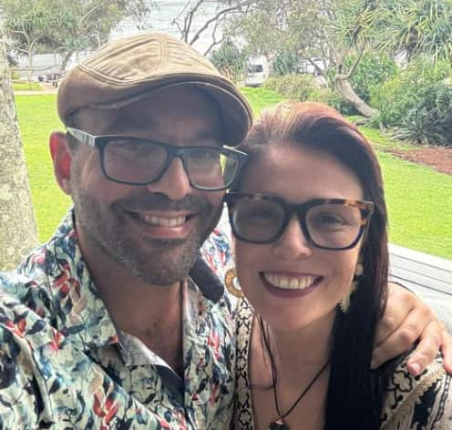A portrait-style photo of a happy couple, smiling at the camera.