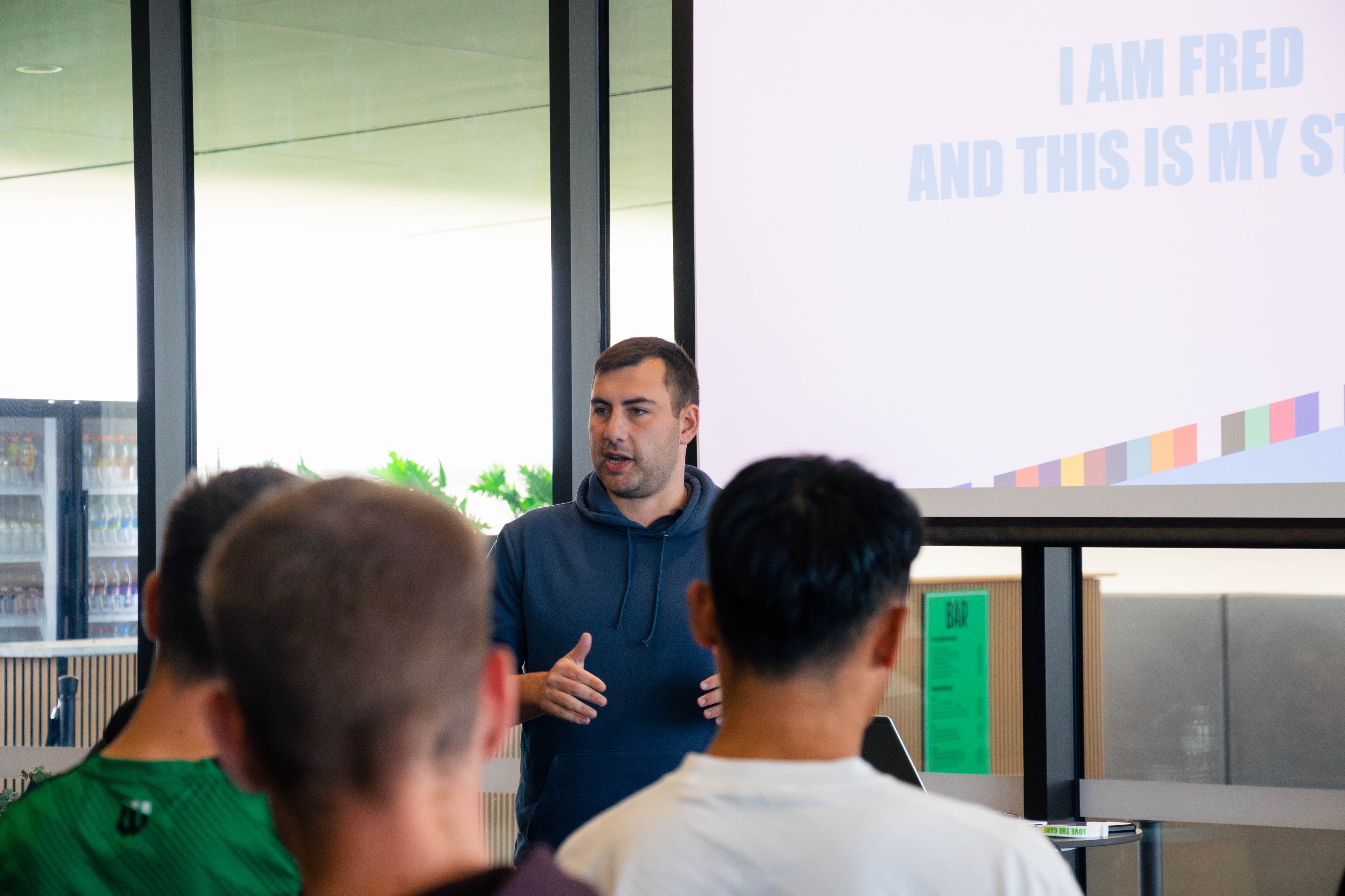 A man in a green shirt addressing audiences